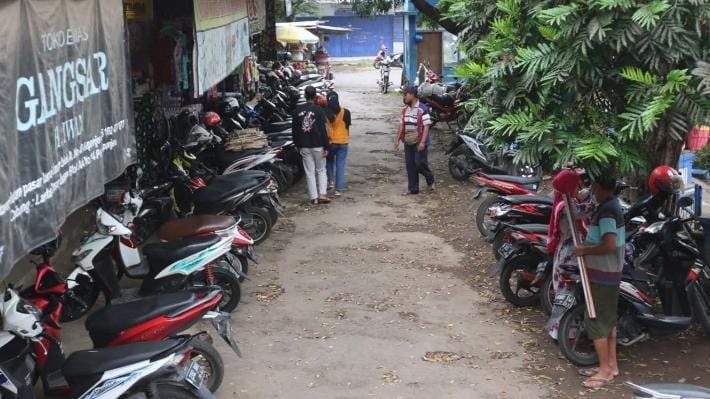 TERJUN BEBAS: Deretan sepeda motor terparkir di Pasar Kepanjen, Jumat (13/1). Tahun 2022 retribusi parkir yang masuk PAD meleset jauh dari target yang diberikan. - DARMONO/RADAR MALANG