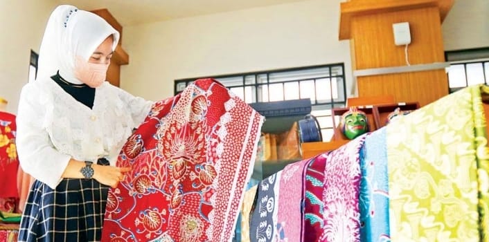 PRODUK LOKAL: Pengunjung memeriksa batik buatan UMKM Kota Malang di Rumah Solusi, beberapa waktu lalu. - Darmono/Radar Malang