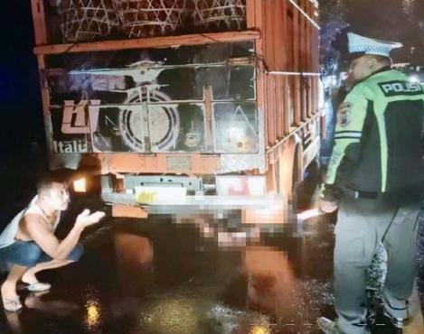 KECELAKAAN: Aparat kepolisian bersama warga mengevakuasi korban kecelakaan yang terlindas truk di Jalan Raya Desa Jatiguwi, Sumberpucung pada Jumat malam (27/1). - Satlantas Polres Malang For Radar Malang