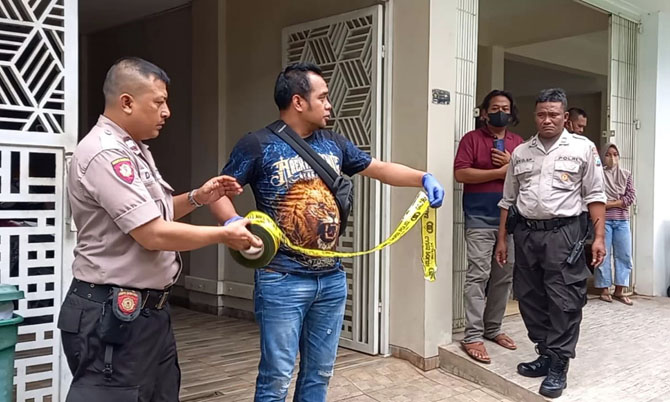 PEMBATAS: Petugas memasang police line di rumah kos tempat meninggalnya Agus Dwi Prasetyo kemarin pagi (7/1).(POLSEK LOWOKWARU FOR RADAR MALANG)