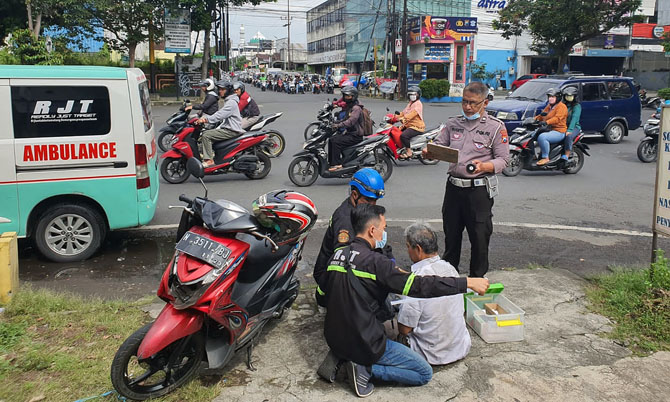 AKIBAT CEROBOH: Relawan memberikan pertolongan pertama kepada Efendi setelah terlibat kecelakaan di perempatan Jalan Jaksa Agung Suprapto. (POLRESTA MALANG KOTA FOR RADAR MALANG)
