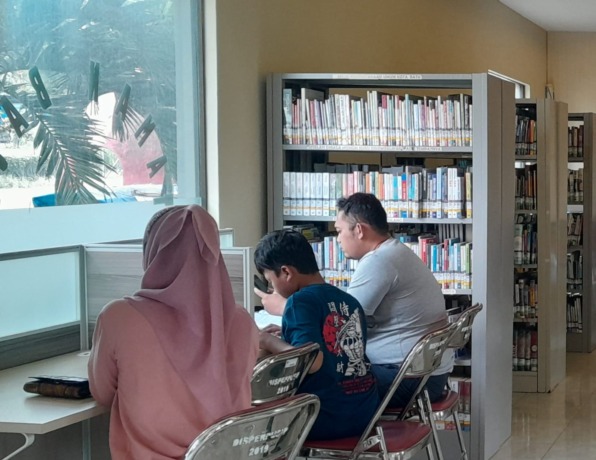 NYAMAN: Sejumlah pengunjung sedang asyik membaca buku. (foto: radar batu)