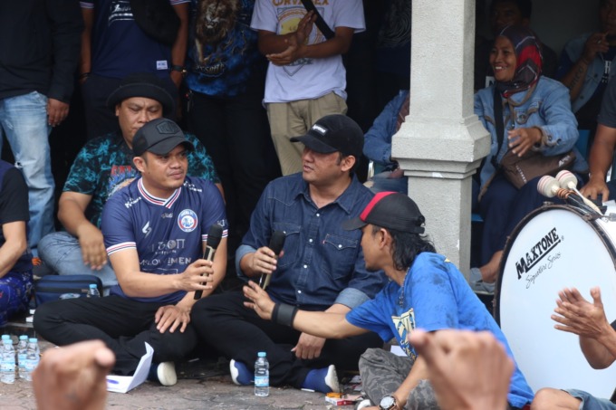 SEMATKAN HARAPAN BARU: Komisaris Arema FC Tatang Dwi Arifianto dan Manajer Singo Edan Wiebie Dwi Andriyas (pegang mic) menemui sejumlah Aremania di Kandang Singa, beberapa waktu lalu. (Darmono / Radar Malang)