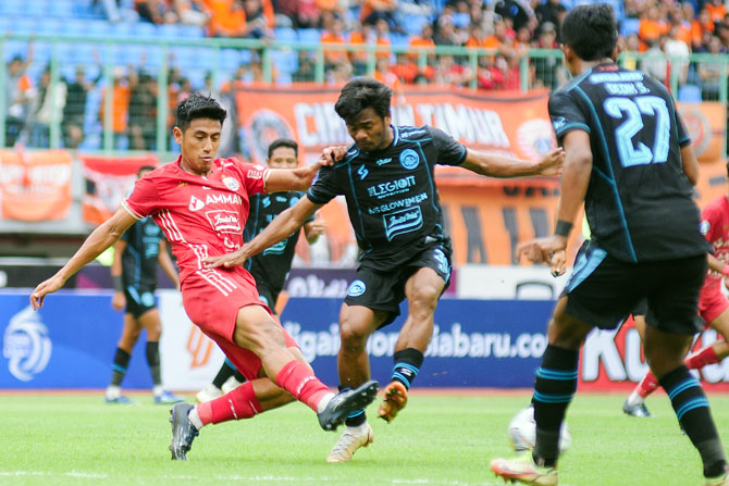 POSISI MELOROT: Ilham Udin (kanan) duel bola versus Hanif Sjahbandi, penggawa Persija di laga kemarin sore (12/2). Singo Edan harus rela kehilangan poin di pertandingan tersebut. (Media Officer Arema FC For Radar Malang)