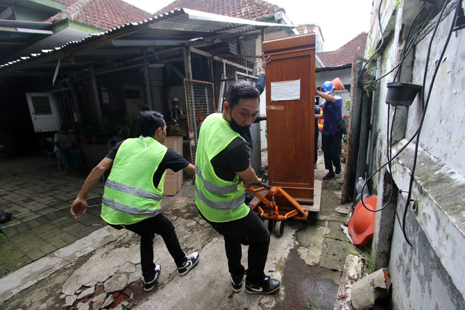 RUMDIS DOKTER: Petugas eksekusi mengangkuti barang-barang dari rumah di Jalan Simpang Ijen, Kelurahan Oro-Oro Dowo kemarin (15/2). (SUHARTO / RADAR MALANG)