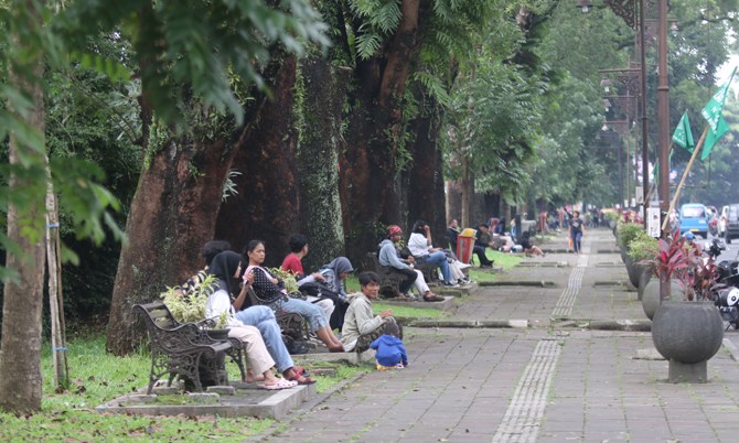 SOLUSI : Warga duduk-duduk di bangku pedestrian Jalan Besar Ijen. (Suharto/Radarmalang)