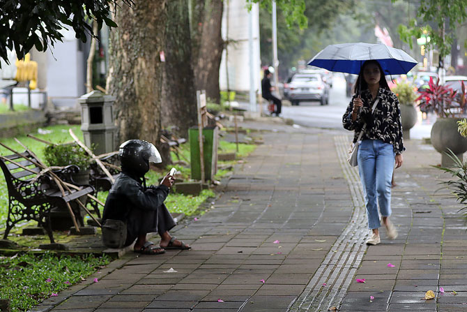 HUJAN : Kursi taman Jalan Besar Ijen yang masih tersegel bambu. (Darmono/Radar Malang)