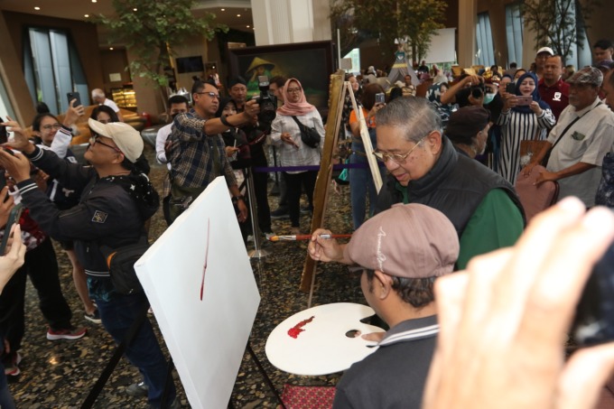 GORESKAN CAT: Susilo Bambang Yudhoyono menggoreskan cat biru ke kanvas milik salah satu pelukis di Hotel Grand Mercure Malang Mirama, kemarin siang (12/2). (DARMONO/RADAR MALANG)