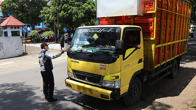 CEK : Petugas Dishub Kota Malang menghentikan truk untuk mengecek surat kelayakan jalan. (Darmono/Radar Malang)