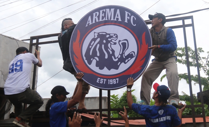 PENUH MAKNA: Ratusan orang bergotong royong mengembalikan logo Arema FC, kemarin siang (31/1).(Darmono / Radar Malang)