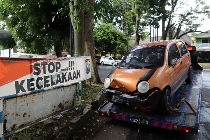 YANG KESEKIAN: Mobil bernomor polisi N 1513 IH langsung dievakuasi setelah menabrak gapura di Jalan Raya Segaran, Desa Kendalpayak, Kecamatan Pakisaji, kemarin siang (4/3).(Darmono / Radar Malang)