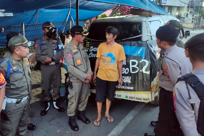 DIPROTES WARGA: Petugas Satpol PP Kota Malang berdialog dengan pemilik warung nasi goreng yang menyediakan menu mengandung babi di Jalan Terusan Dieng, Kelurahan Pisang Candi, Kecamatan Sukun, kemarin sore (20/3).(SATPOL PP KOTA MALANG FOR RADAR MALANG)