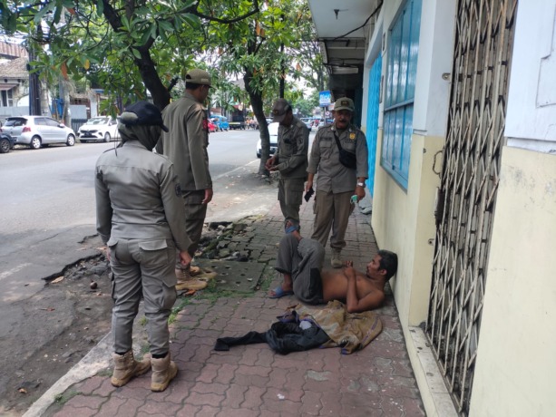 BIKIN RESAH: Tim Satpol PP bersiap meringkus ODGJ yang kerap mengamuk dan melempar batu di Jalan Kauman kemarin siang (23/3). (SATPOL PP KOTA MALANG FOR RADAR MALANG)