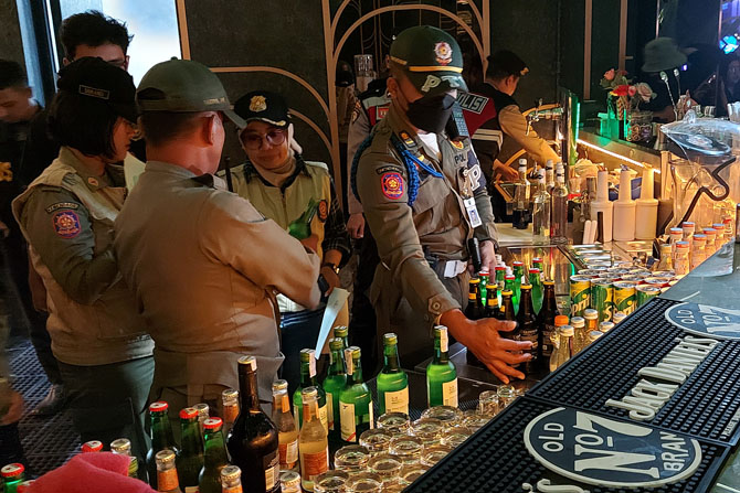 OPERASI PEKAT: Petugas memeriksa deretan botol minuman beralkohol di salah satu rumah hiburan malam, beberapa waktu lalu. (BIYAN MUDZAKY HANINDITO / RADAR MALANG)