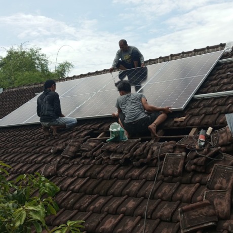 TEKAN BIAYA: Petugas memasang rangkaian panel surya di genteng SDN Lowokwaru 1 beberapa waktu lalu. (istimewa)