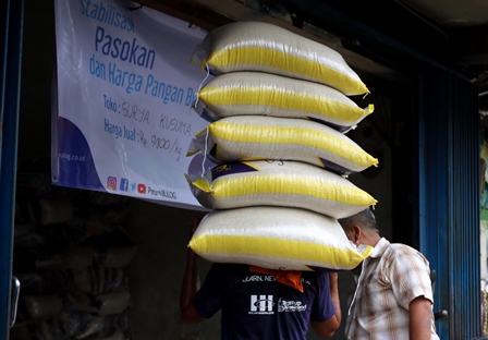 PASOKAN BERAS: Seorang pekerja mengangkuti beras untuk dimasukkan ke salah satu toko di Jalan Kyai Tamin, Kota Malang. (darmono/radar malang)