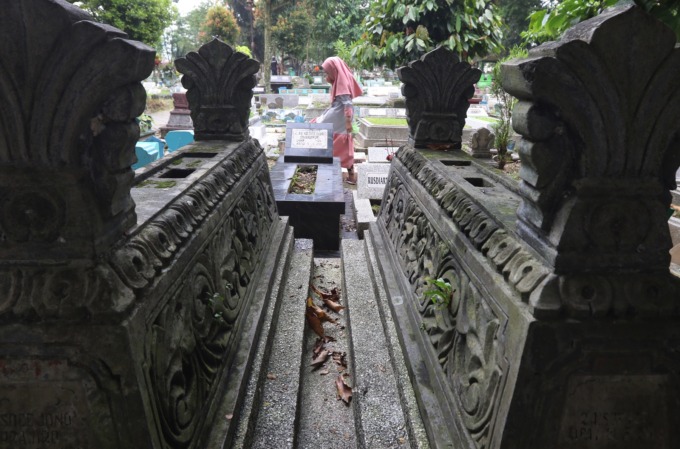ZIARAH: Satu bocah melintasi sejumlah makam di TPU Kasin setelah melakukan ziarah kubur. (darmono/radar malang)