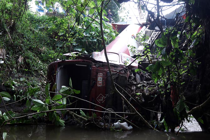 TUNGGU MOBIL DEREK: Truk Pertamina bernopol N 9359 UA terperosok ke Sungai di Jalan Raya Diponegoro, Desa Krebet Senggrong, Kecamatan Bululawang, dini hari kemarin (26/3) sekitar pukul 01.00.(Darmono / Radar Malang)