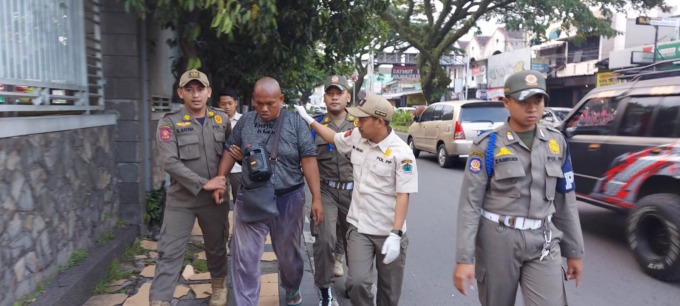 BIKIN RESAH: Petugas Satpol PP Kota Malang menangkap Mahendra Aji di pertigaan depan Masjid Sabilillah, Blimbing, Rabu (22/3). (BIYAN MUDZAKY HANINDITO/RADAR MALANG