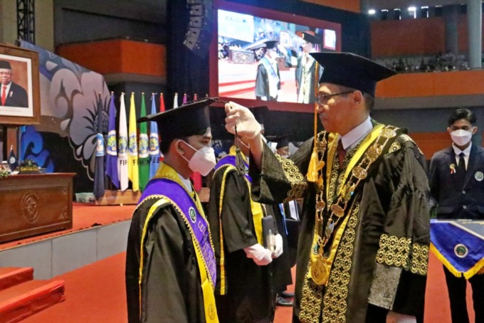 TANTANGAN ABAD 21: Rektor UM Prof Dr Hariyono MPd menggeser pita toga kepada salah satu wisudawan sebagai tanda kelulusan