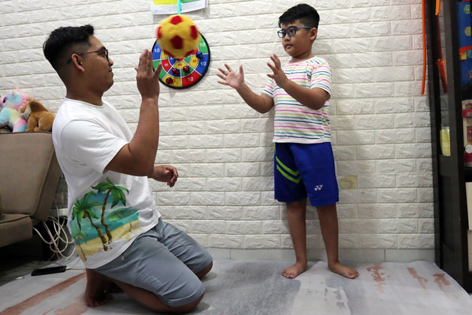 HOBI BOLA: Zefranino Ferdiansyah bermain bola bersama ayahnya dengan sangat hati-hati agar tidak terjatuh. (Darmono/Radar Malang)