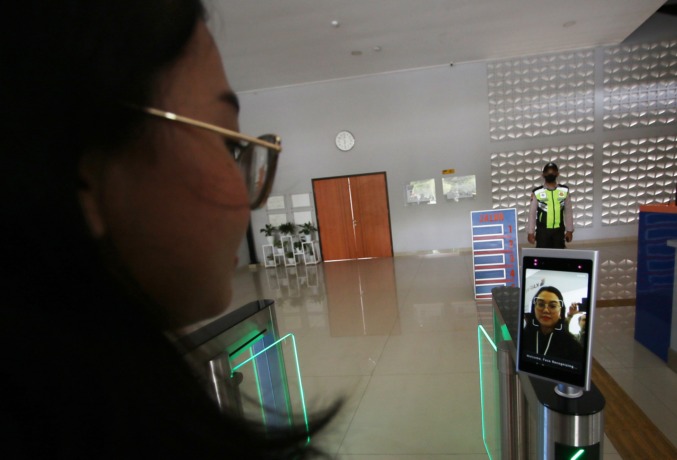 LEBIH CEPAT: Penumpang KA melakukan scan wajah pada face recognition boarding gate untuk boarding pass tiket di Stasiun Malang Kota Baru, kemarin siang. (suharto/radar malang)