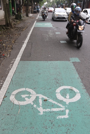 LANGGAR ATURAN: Beberapa pengendara sepeda motor melintasi jalur khusus sepeda di Jalan Kauman, Klojen.(Darmono/Radar Malang)
