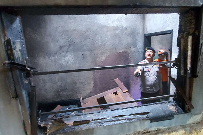 SEMPIT: Polisi memeriksa kamar di lantai dua rumah Sondik Santoso di Jalan Kolonel Sugiono Gang 3B Nomor 14, Kelurahan Mergosono, setelah terbakar pada Minggu siang (19/3). (BIYAN MUDZAKY HANINDITO/RADAR MALANG)