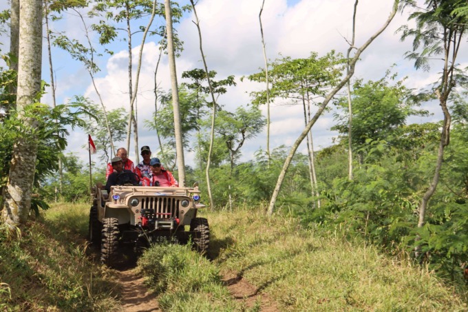 DIAJAK OFFROAD: Wabup Malang Drs. Didik Gatot Subroto SH MH (kanan) bersama rombongan melintasi sungai dengan kendaraan Jeep. (PROKOPIM KABUPATEN MALANG FOR RADAR MALANG)