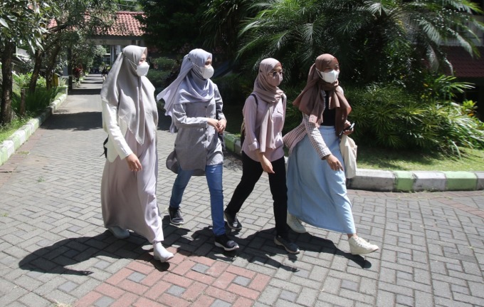 SEGERA DATANG: Empat mahasiswa UM berjalan menuju ruang kuliah, Jumat lalu (10/3). Kota Malang segera kedatangan mahasiswa luar kota yang diprediksi mencapai 10 ribu orang. (suharto/radar malang)