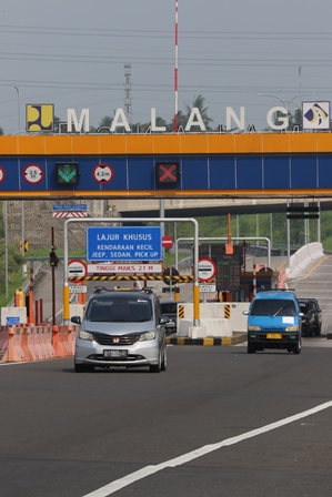 LALU LINTAS: Beberapa kendaraan keluar dari tol Malang kemarin. PT Jasa Marga Pandaan-Malang memperkirakan, jumlah kendaraan saat Lebaran tahun ini lebih banyak dibanding Lebaran sebelumnya. (Darmono/Radar Malang)