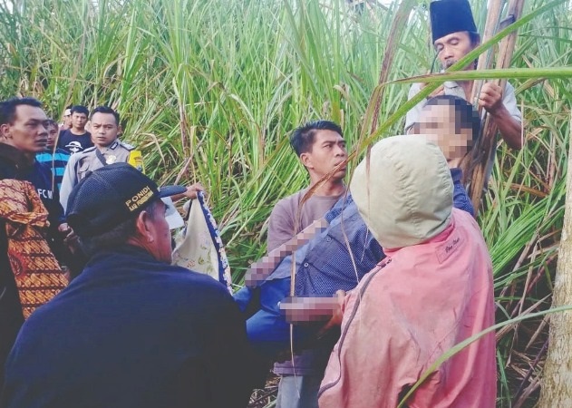 AKHIRI HIDUP: Petugas dibantu warga mengevakuasi jenazah Tukijo Dusun Panggungsari, Desa Baturetno, Kecamatan Dampit yang ditemukan meninggal bunuh diri. (Polsek Dampit for Radar Malang)