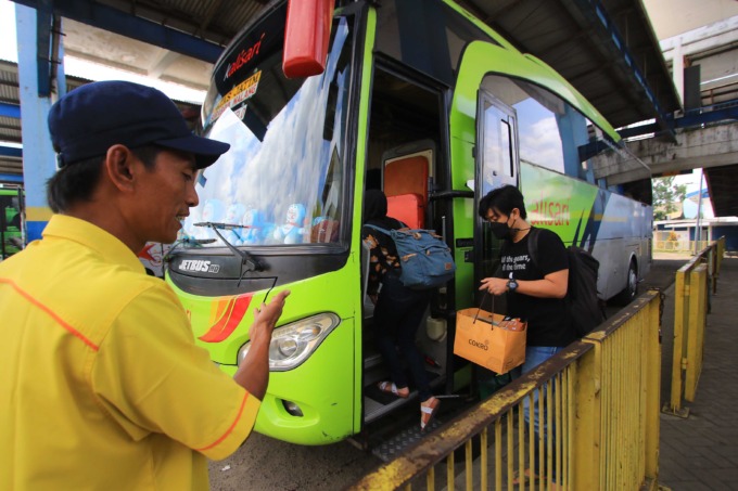 BERANGKAT: Kondektur mengarahkan penumpang naik bus nonekonomi trayek Malang-Surabaya di Terminal Arjosari. (suharto/radar malang)