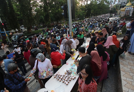 BERBAGI: Pengendara yang didominasi kendaraan roda dua berjubel di sepanjang Jalan Veteran kemarin (11/4). Beberapa di antara mereka menepi untuk menerima bingkisan takjil dari penyewa tenant di Matos.