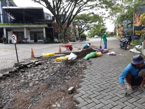 INFRASTRUKTUR: Pekerja mengebut perbaikan paving yang ambrol di Jalan Lembah Dieng, Kelurahan Pisang Candi, Kecamatan Sukun kemarin (29/4)