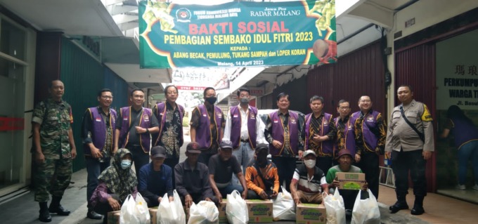 RUTIN TAHUNAN: Pengurus dan anggota FKWTMR foto bersama para penerima bantuan di acara Baksos Pembagian Sembako Idul Fitri 2023 kepada Abang Becak, Pemulung, Tukang Sampah dan Loper Koran, Jumat (14/4) tadi siang. (IMA/RADAR MALANG)