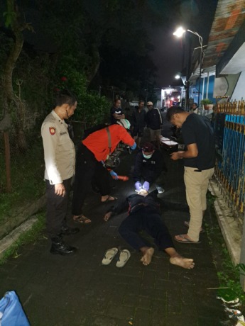 SERANGAN JANTUNG: Relawan dan polisi memeriksa tubuh pria tanpa identitas yang meninggal di Jalan Plaosan Barat Gang 2, RT 04/RW 08, Kelurahan Purwodadi, Kecamatan Blimbing, Minggu pagi (23/4). POLSEK BLIMBING FOR RADAR MALANG