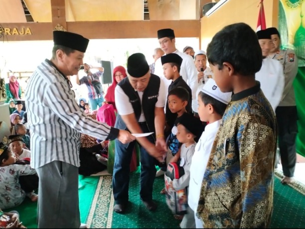 Komisaris Utama PT Anugerah Citra Abadi Iwan Kurniawan (kiri) dan Bupati Malang Drs HM Sanusi MM (tengah) menyantuni anak yatim di titik terakhir, pendapa Kecamatan Karangploso, kemarin (7/4)