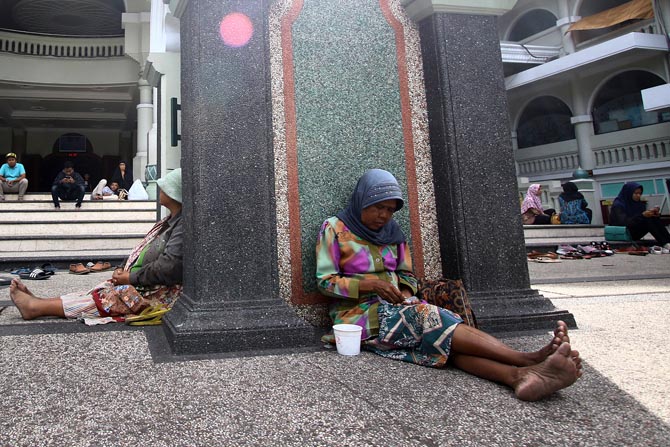 DUDUK : Pengemis duduk di depan salah satu masjid besar di Kota Malang, beberapa waktu lalu. (Dokumentasi Radar Malang)