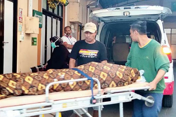 DIBUNUH ANAK SENDIRI: Pemeriksaan lebih lanjut dilakukan polisi pada jenazah Sunarsih di RSSA Malang, kemarin siang. Setelah itu jenazahnya dibawa ke rumah duka. (Nabila Amelia / Radar Malang)