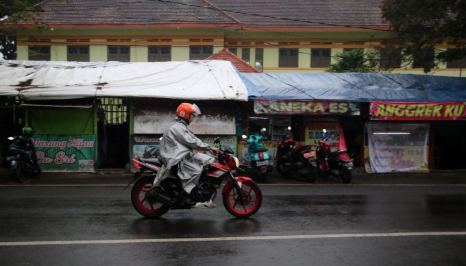 MENGANTAR PESANAN: Driver ojol melintas di Jalan Terusan Ijen untuk mengantar makanan pesanan customer, kemarin siang. (darmono/radar malang)