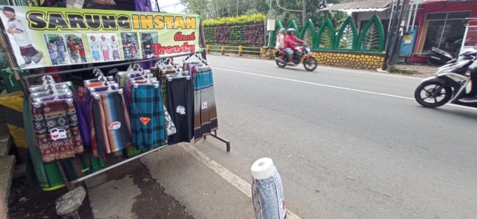 SIMPEL: Warga Kelurahan Sisir menjajakan sarung instan untuk anak di Jalan Brantas Kota Batu.