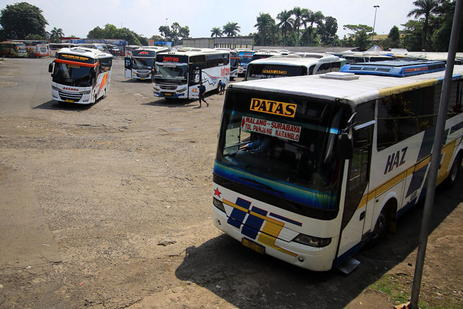 PUNCAKNYA HARI INI: Beberapa armada bus beroperasi di Terminal Arjosari, kemarin. Jumlah penumpang yang datang terus bertambah sejak beberapa hari terakhir.(Suharto / Radar Malang)