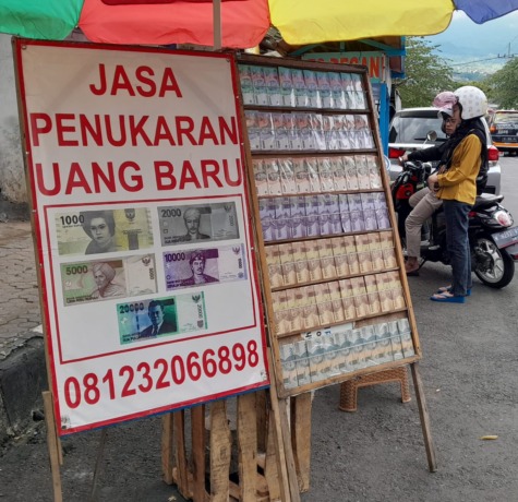 TUNGGU PENUKAR: Salah satu stan penukaran uang di Jalan Brantas, Kelurahan Sisir, Kota Batu belum banyak dikunjungi.