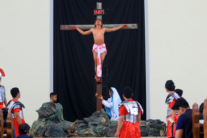 KHIDMAT: Remaja Gereja Katolik St Yohanes Pemandi Janti, Kecamatan Sukun, membawakan teatrikal Visualisasi Kisah Sengsara Yesus kemarin (7/4). (Suharto/Radar Malang)