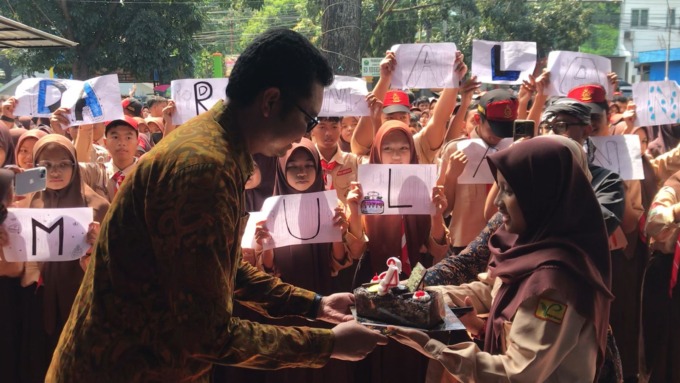 DIBERI KEJUTAN: General Manager Jawa Pos Radar Malang Don Virgo (kiri) menerima kue tart dan ucapan selamat ulang tahun dari siswa-siswi SMPN 6 Malang, kemarin (19/5). (dika rabbaniy firdaus/radar malang)
