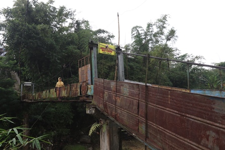 BUTUH PERHATIAN: Warga melintasi jembatan gantung di Kepuh Gang 4 Kelurahan Bandungrejosari, Kecamatan Sukun kemarin (3/5). (Darmono/Radar Malang)