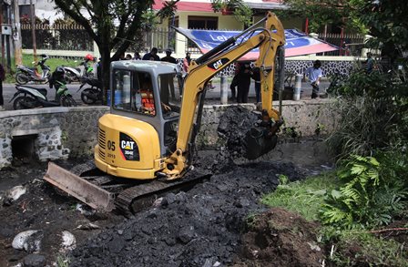 CEGAH BANJIR: Satu unit alat berat mengeruk sedimentasi di drainase kawasan Dieng, Kota Malang.  (Suharto/Radar Malang)