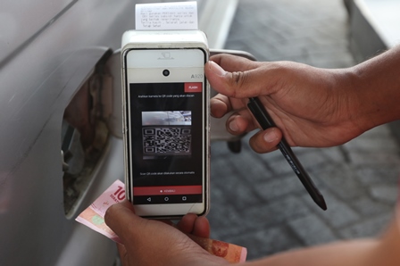 DEMI SUBSIDI: Petugas di Stasiun Pengisian Bahan Bakar Umum (SPBU) Embong Brantas melayani pembeli menggunakan aplikasi QR Code, kemarin (30/5). (Darmono/Radar Malang)