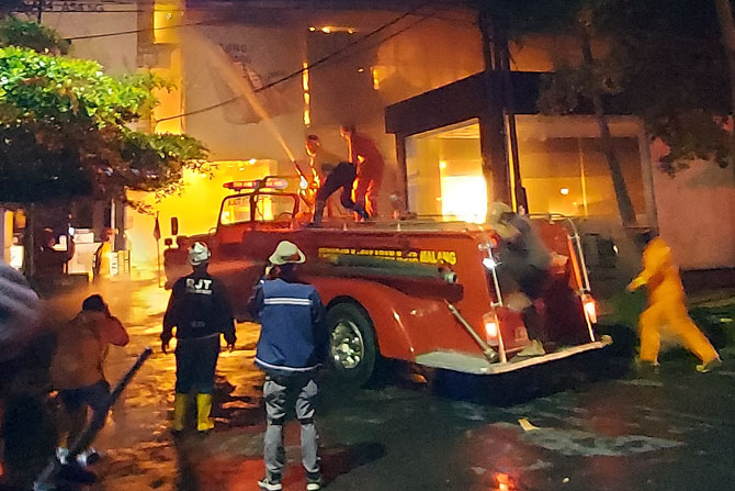 BERJIBAKU : Petugas Damkar berjuang melawan api yang melahap Malang Plaza. (Biyan/Radar Malang)